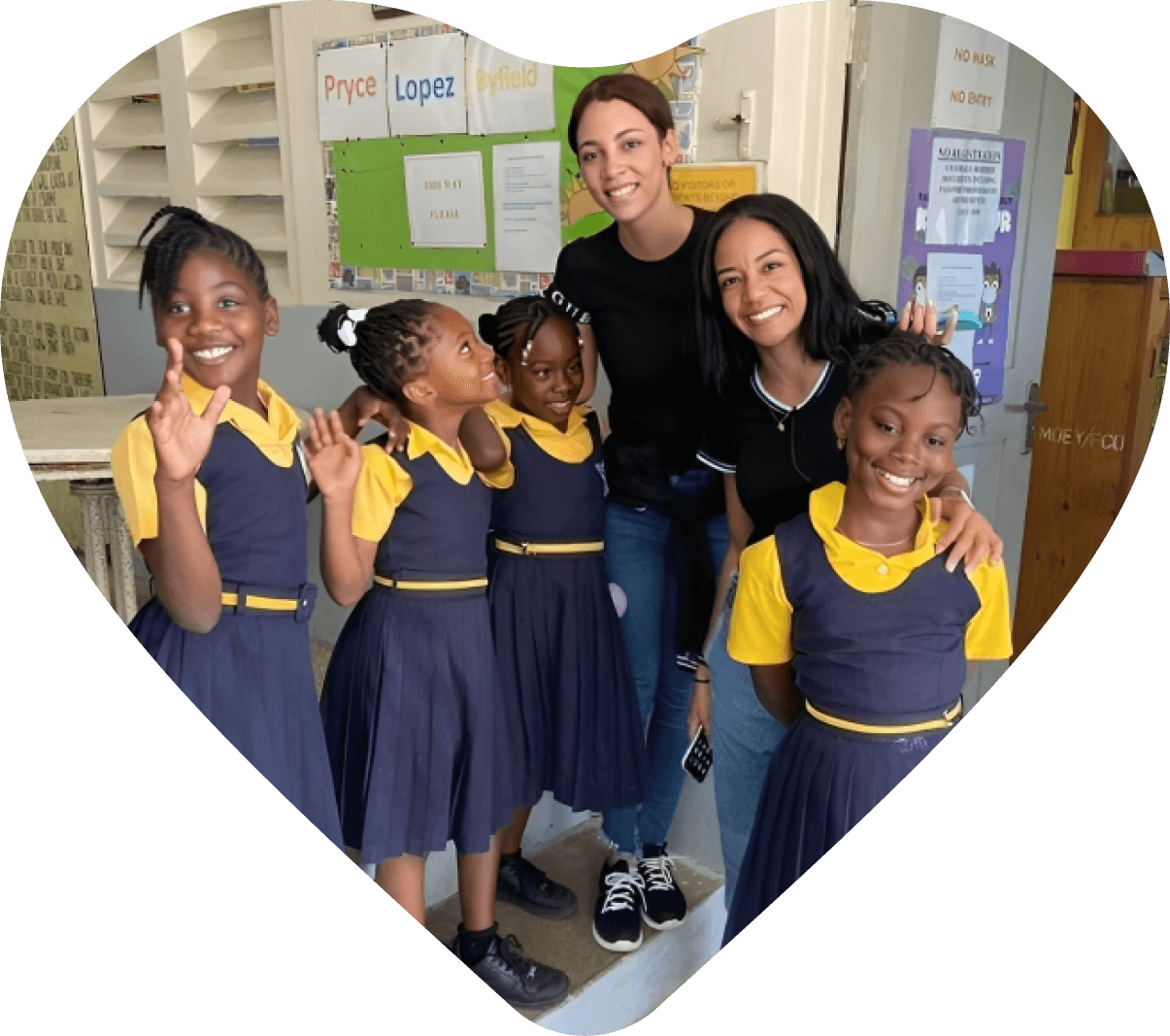 Smiling schoolgirls with teachers in classroom.