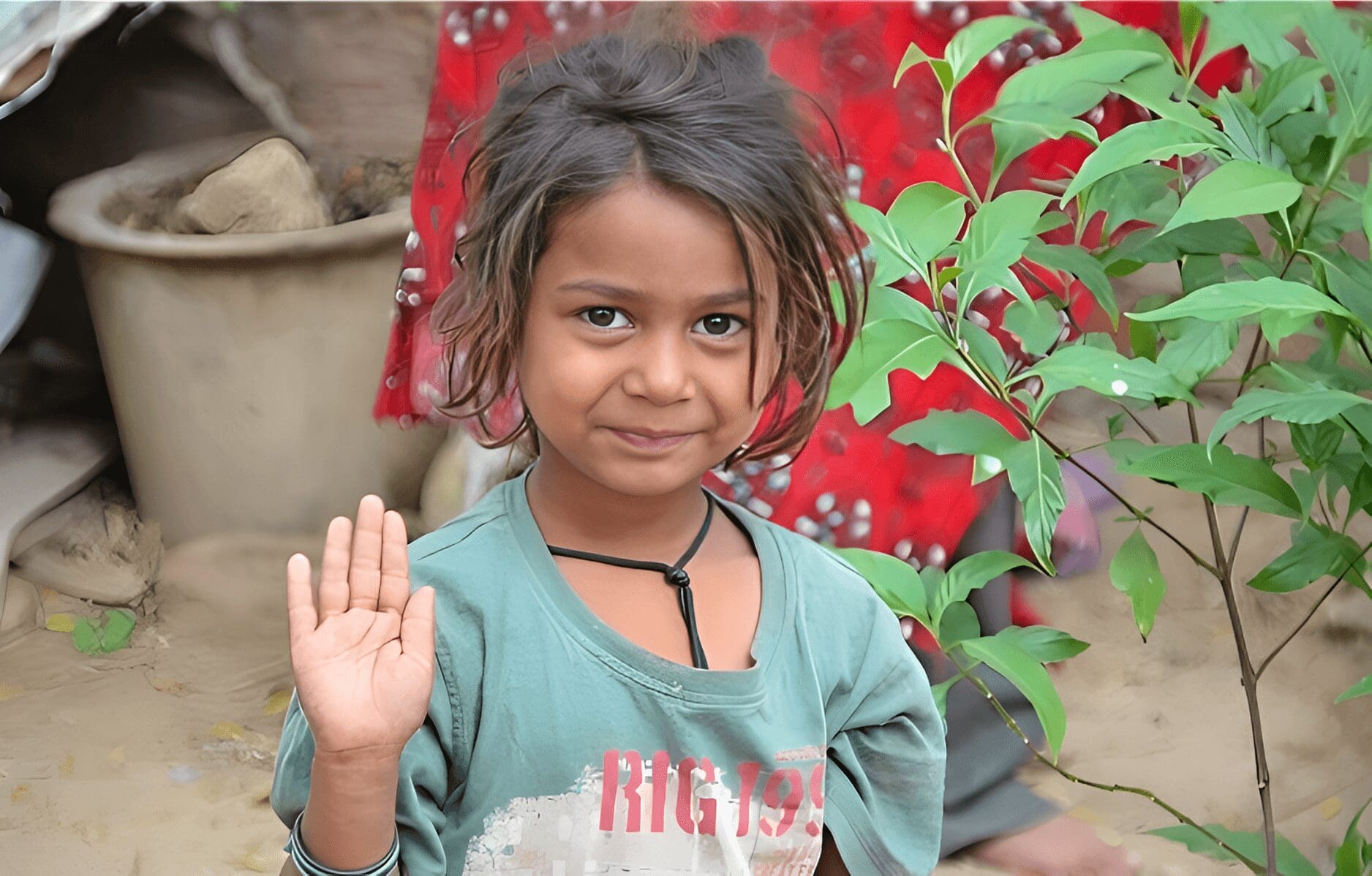 Smiling girl waves hello outdoors.